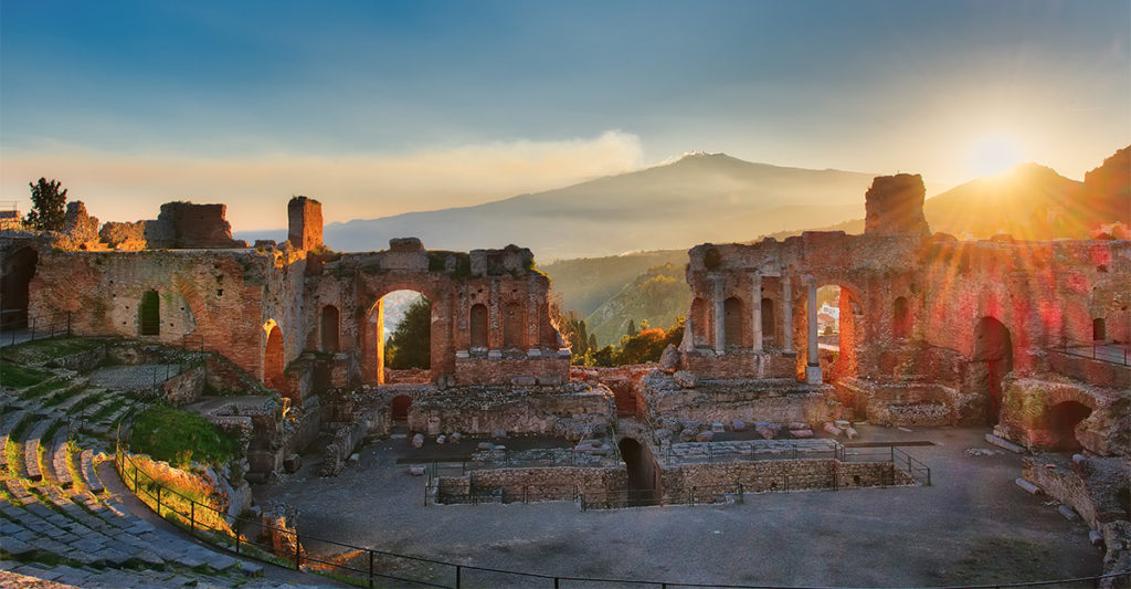 Particular of Ancient theatre of Taormina Sicily Italy with Etna erupting volcano at sunset
